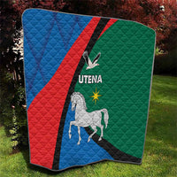 Folded quilt blanket on lawn, blue red green diagonal stripe with horse and Utena text