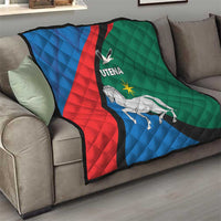 Quilt blanket on sofa, blue red green diagonal stripe with white horse and Utena logo