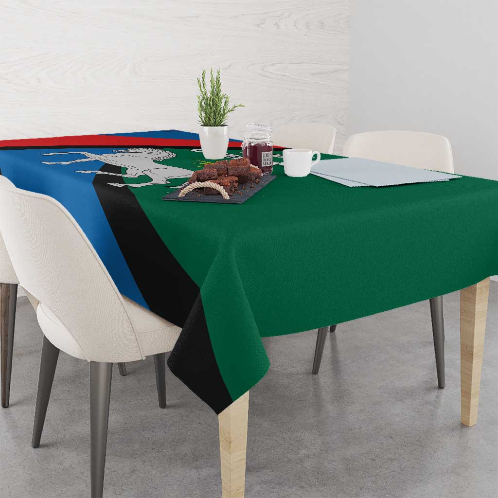 Utena patterned tablecloth draped over dining table with blue red green and black stripe