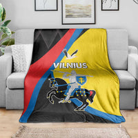 Vilnius flag blanket draped on sofa; yellow, black, red, and blue with large emblem