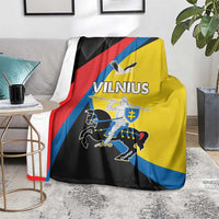 Vilnius flag blanket over sofa; yellow, black, red, and blue diagonal panels with text
