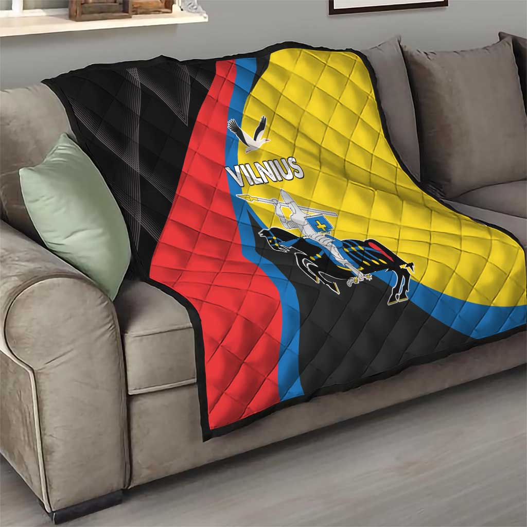 Folded Vilnius flag quilt on couch; black, red, yellow, and blue quilted pattern