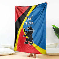 Flag-themed blanket with Telsiai emblem and text, draped upright on the floor