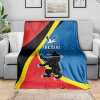 Flag-themed blanket in red, blue, black, and yellow on a couch with emblem and text