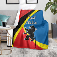 Flag-themed blanket with Telsiai emblem and text, draped on a couch