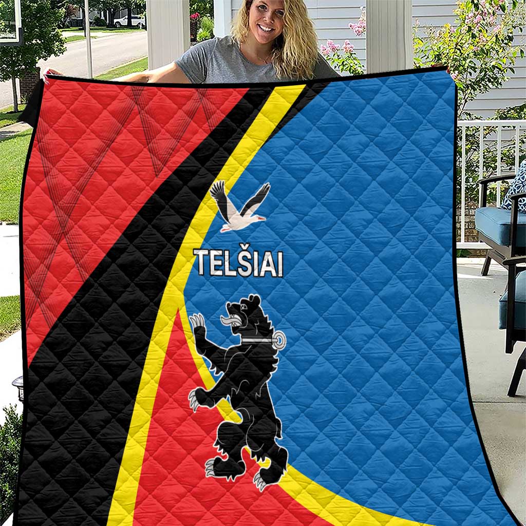 Red and blue quilt with yellow stripe, black diagonal panel, and “TELSIAI” emblem