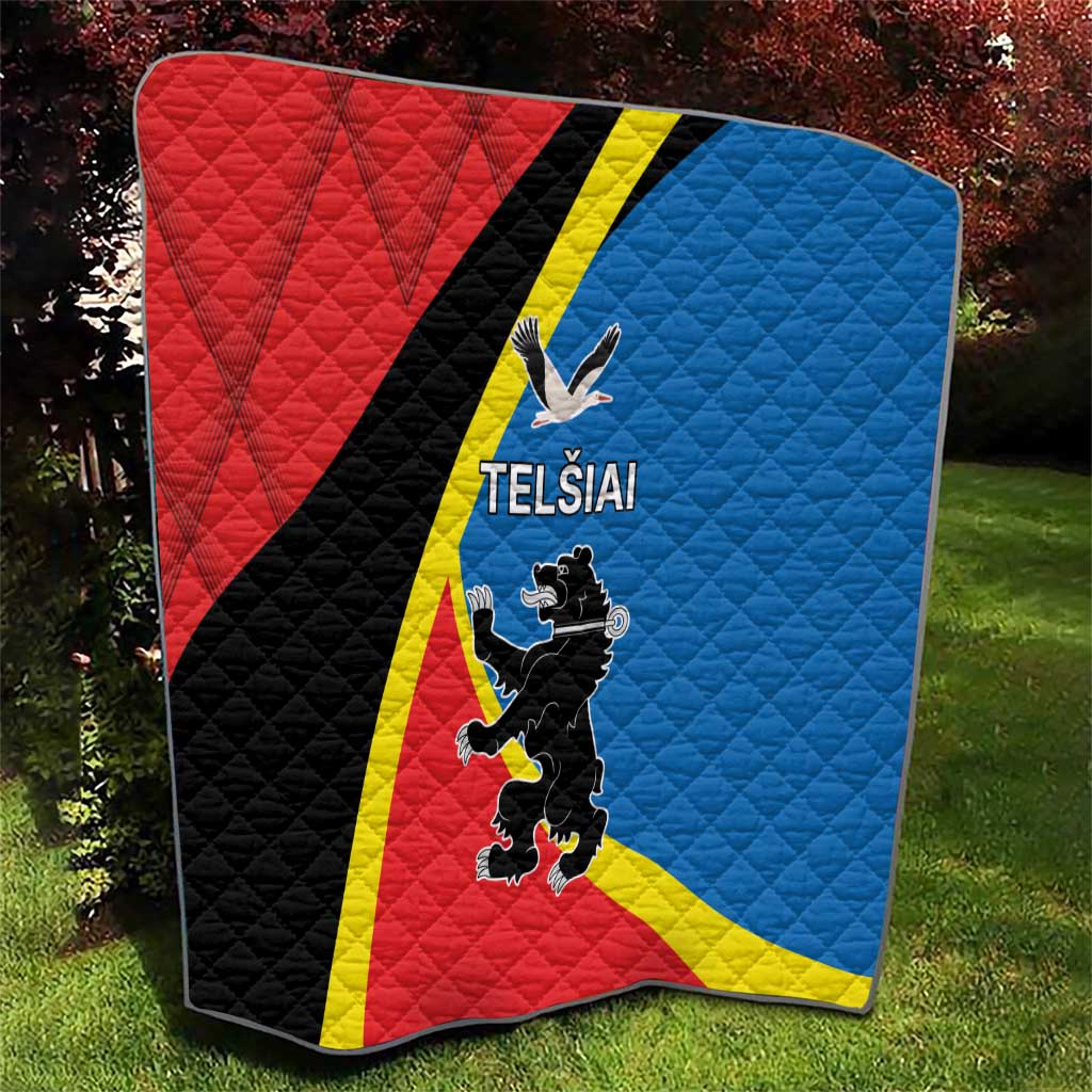 Red and blue quilt with yellow stripe, black diagonal section, and “TELSIAI” print