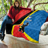 Red, blue, and black quilt with yellow stripe and “TELSIAI” emblem, diamond-quilted texture