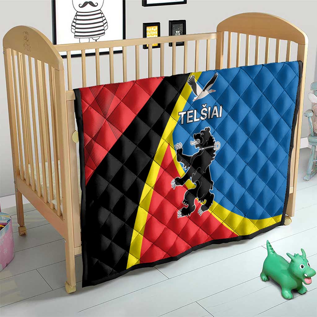Red and blue quilt with yellow stripe and “TELSIAI” crest displayed on a crib bed