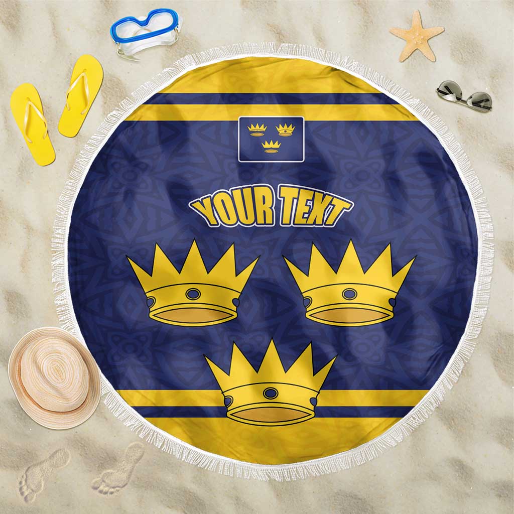 Blue and yellow round beach blanket with crown emblem and white fringed edge