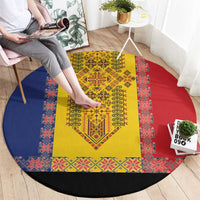 Round embroidered carpet with yellow central motif, red-blue patterned border, black trim