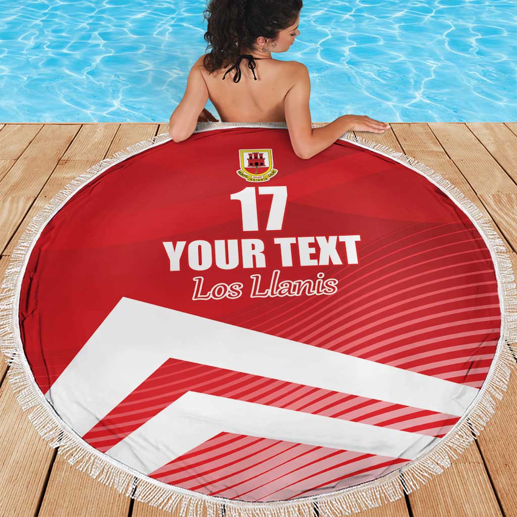 Red circular beach blanket with fringe, crest at top, “YOUR TEXT”, “Los Llanis” and 17