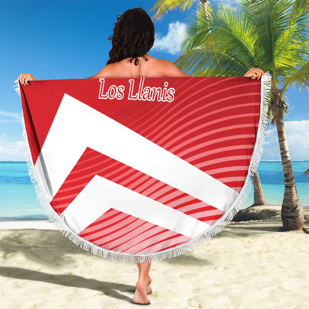 Red circular beach blanket with fringe, “Los Llanis” script and diagonal white stripes