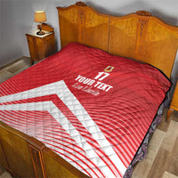 Red quilt blanket with diamond quilting, number 17 and crest, and white diagonal stripe on bed