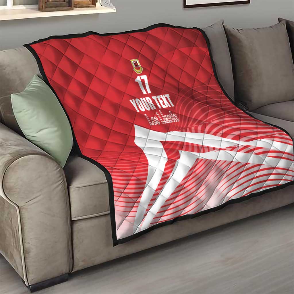 Red quilt blanket with diamond quilting, crest and number 17, with white diagonal stripe on sofa