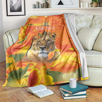 Orange personalized blanket with lion face, crown emblem, and tulip flowers, on sofa