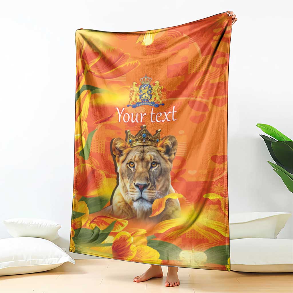 Orange personalized blanket with lion face and crown emblem, hanging over a couch