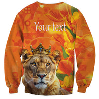 Orange crewneck sweatshirt with lion face and crown graphic, hearts and tulips