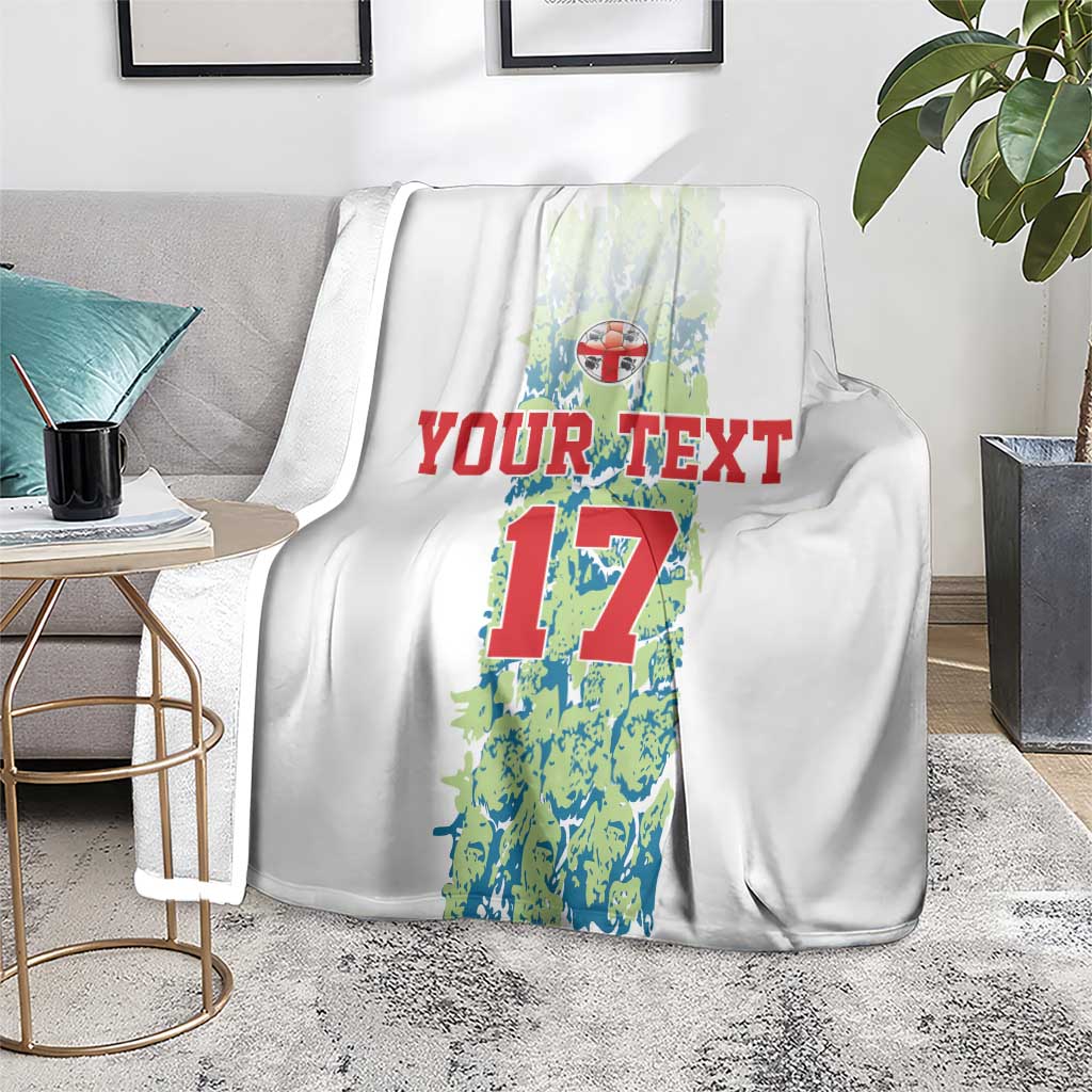 Custom football blanket on floor, white with number 17 graphic and red “YOUR TEXT”