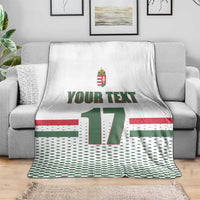 White custom ice hockey blanket on gray sofa; Hungary crest, 'YOUR TEXT', number 17