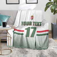 White custom ice hockey blanket over gray sofa; Hungary crest, 'YOUR TEXT', number 17