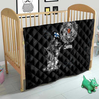 Black quilt with diamond stitching and white Viking ship graphic on crib bedding with crest and “Suomi”