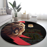 Round black rug with lion head, small crown coat-of-arms crest, and red diagonal stripe