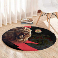 Round black rug with lion face print, crown crest, and red/green coat-of-arms pattern