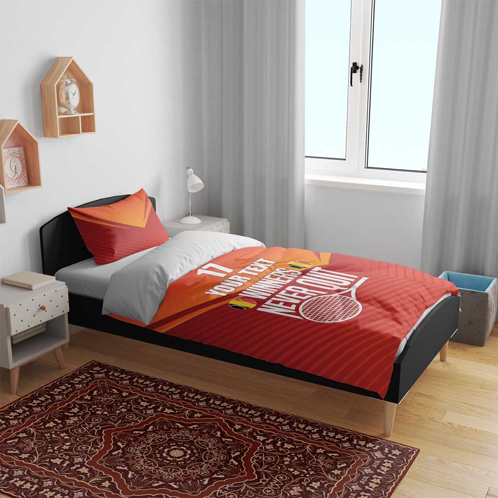 Red and orange bedding on bed with two pillows, tennis graphic and “WINNERS NEVER QUIT”