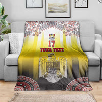 Custom Romania football blanket draped on sofa, yellow gradient with crest and red rim