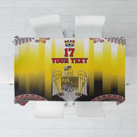 Yellow tablecloth with central 17 emblem, black band, and red geometric edge