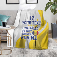 Sports football blanket on floor, white with yellow stripes and “ONE GOAL…” message
