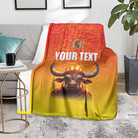 Personalized Spain blanket with crowned bull and 'YOUR TEXT' on gray couch