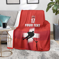Red ice hockey blanket with hockey player silhouette, YOUR TEXT, and 17 print, draped
