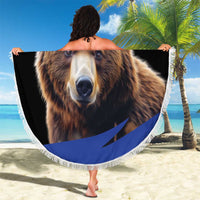 Round bear beach blanket with fringed border, held on sandy beach