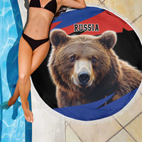 Round beach blanket with Russia bear graphic and fringed edge beside pool