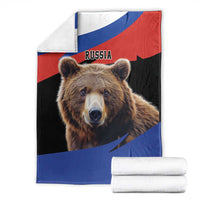 Brown bear blanket with Russia flag print, folded with stacked white towels