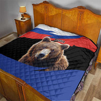 Quilt blanket with brown bear print and Russian flag banding, on a bed