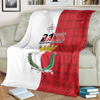 Flag-style Malta Independence Day blanket on a sofa, showing red shield coat of arms