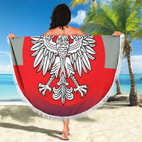 Round beach blanket held open, showing crowned eagle crest on red circle with white border fringe