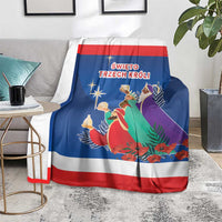 Blue Three Kings Day blanket on armchair with red-and-white border and three kings art