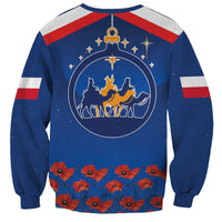 Blue sweatshirt with circular Three Kings graphic and red flower row