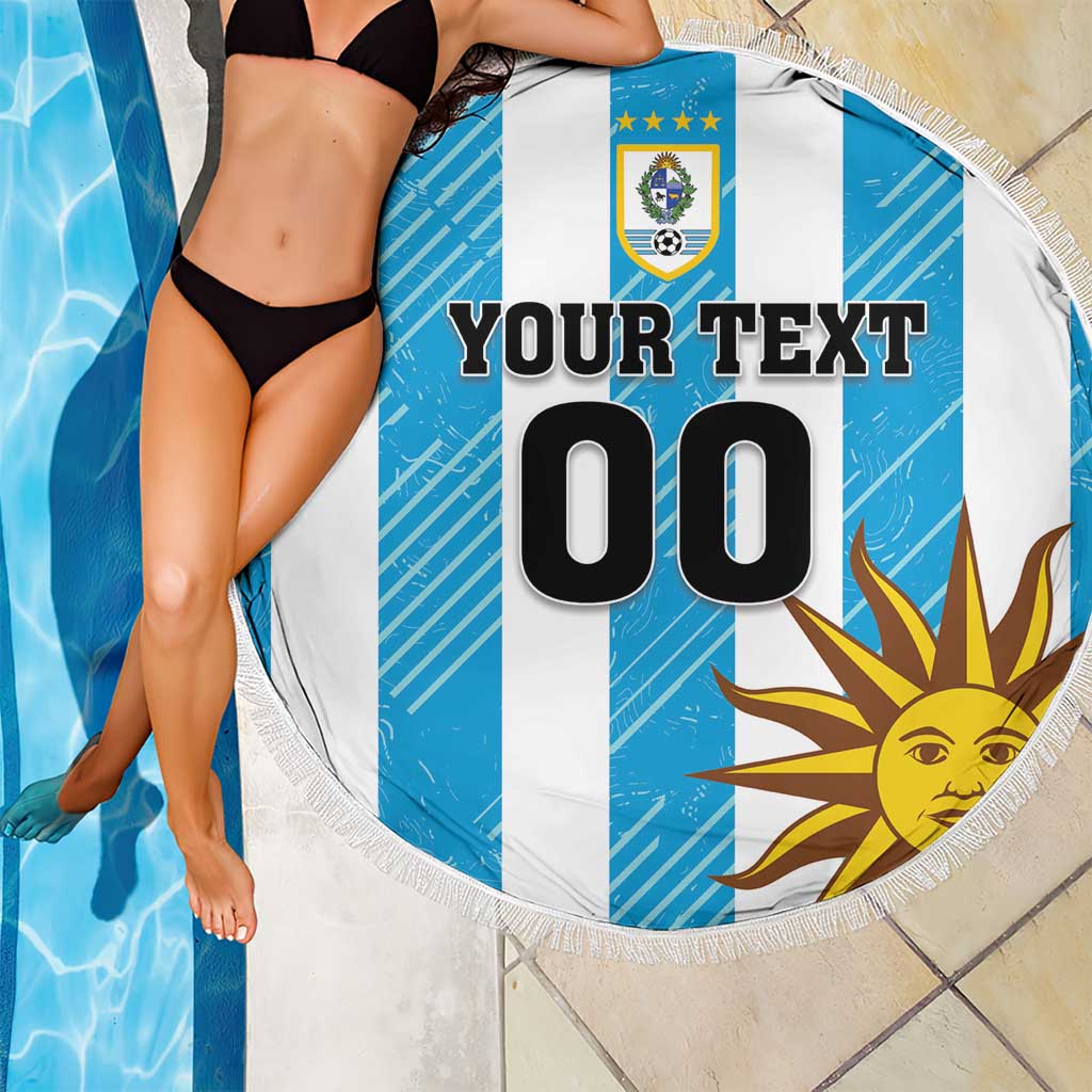 Round beach blanket showing Uruguay crest and sun graphic on blue-and-white stripes