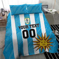 Blue bedding set with white stripes, sun design, crest, and "YOUR TEXT 00" on duvet.