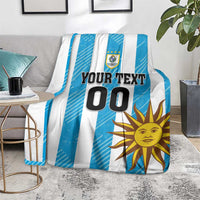 Blue and white striped football blanket draped over sofa, showing sun graphic and 'YOUR TEXT 00'.