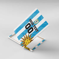 Blue striped canvas wall art with Uruguay crest, sun icon, and YOUR TEXT 00