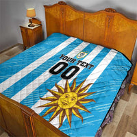 Blue football quilt on bed with white stripes, sun artwork, crest logo, and number 00