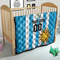 Blue football quilt in crib with white stripes, crest logo, sun graphic, and custom 00