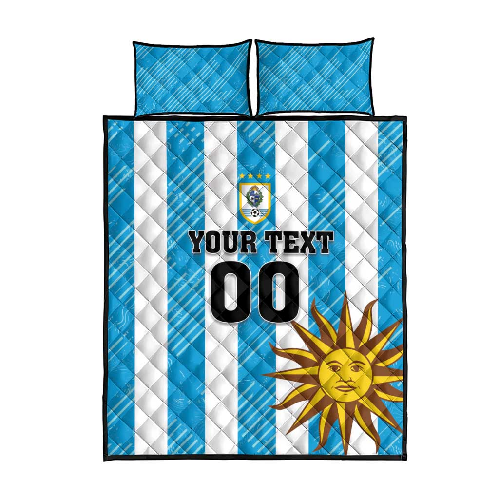Blue and white striped quilt with sun emblem, YOUR TEXT 00, and two matching pillows