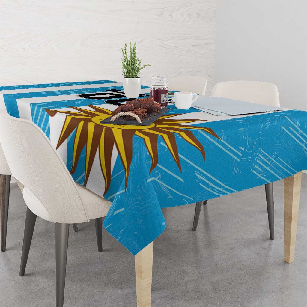 Blue Uruguay football tablecloth on a dining table with sunburst artwork, folded corners